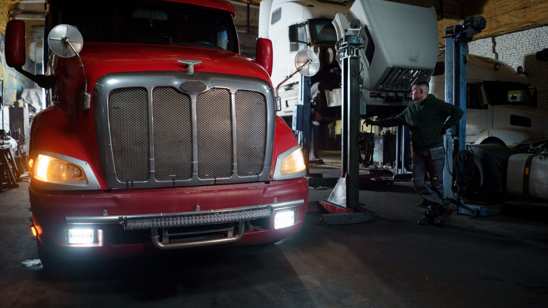 Diesel mechanic servicing a truck engine in a repair shop